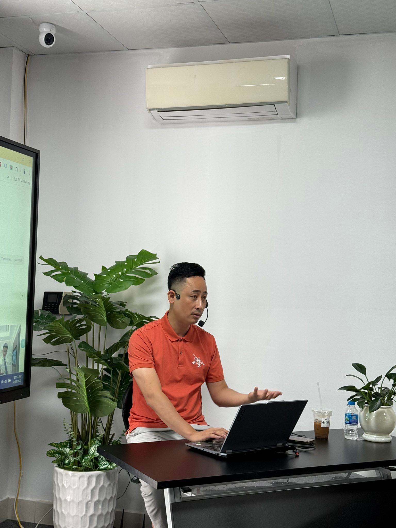 Đăng Dương đeo tai nghe có mic, ngồi trước laptop trong một buổi hướng dẫn trực tuyến