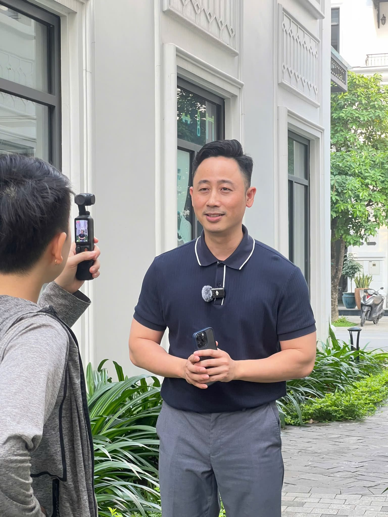 Đăng Dương đang quay video bên ngoài một căn shophouse