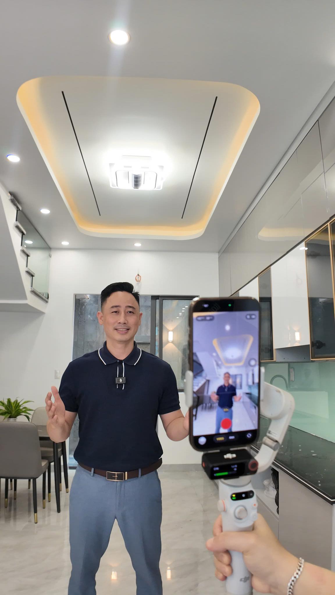 Đăng Dương đang quay video bất động sản bằng điện thoại gắn gimbal trong một căn nhà