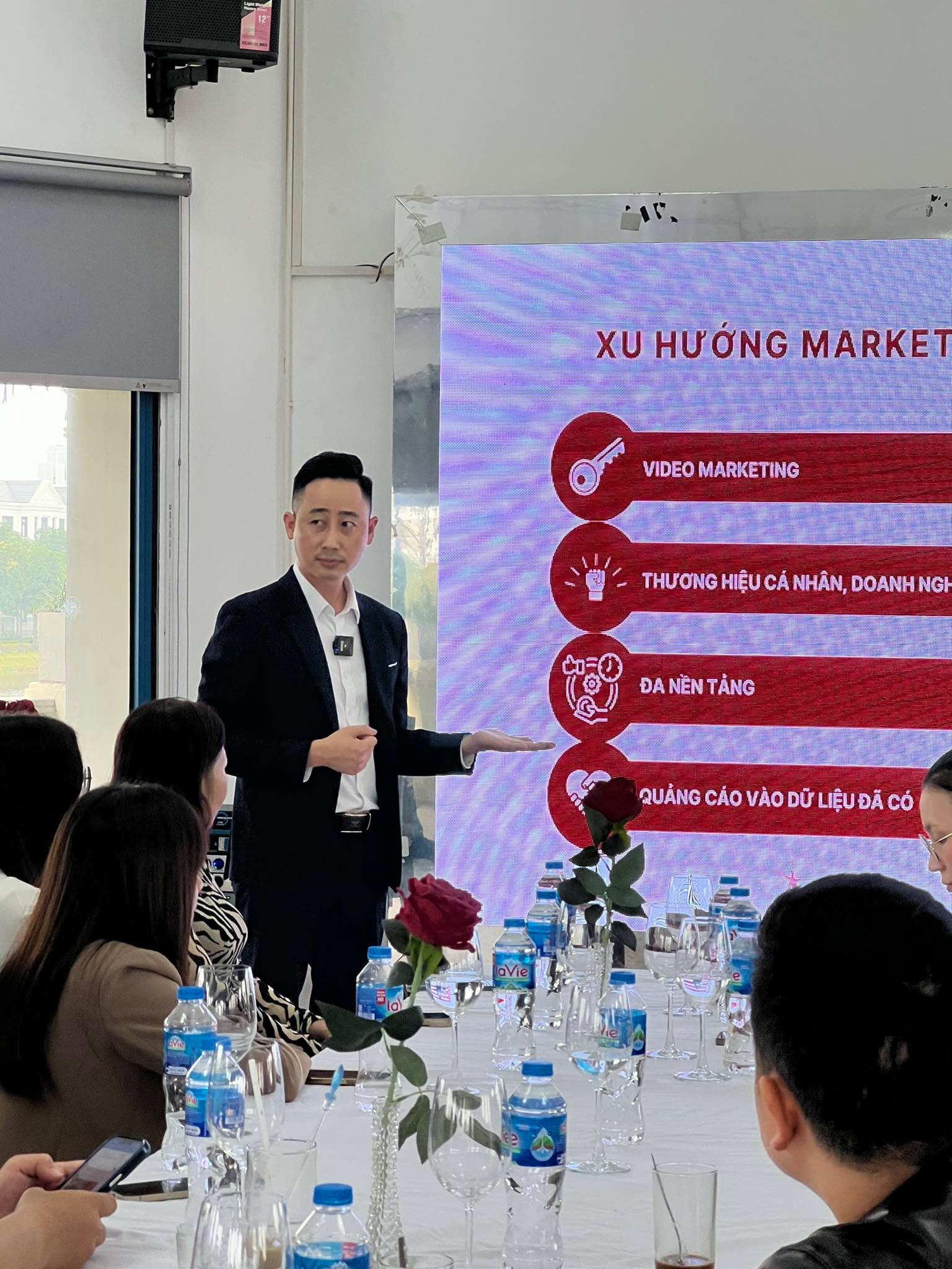 Đăng Dương thuyết trình trước màn hình LED có slide về xu hướng marketing