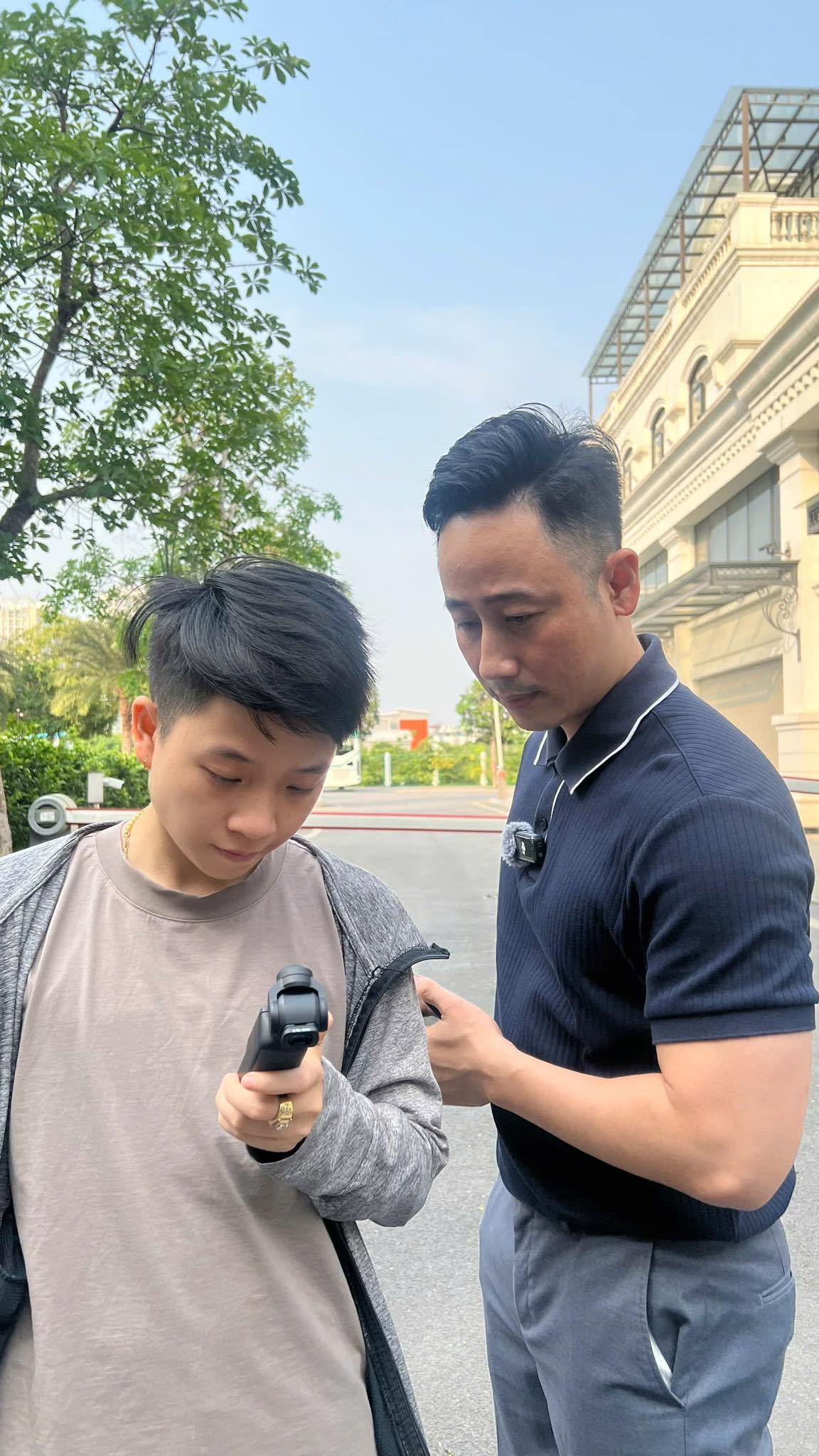 Đăng Dương trao đổi cùng một bạn trẻ đang cầm máy quay cầm tay ngoài trời