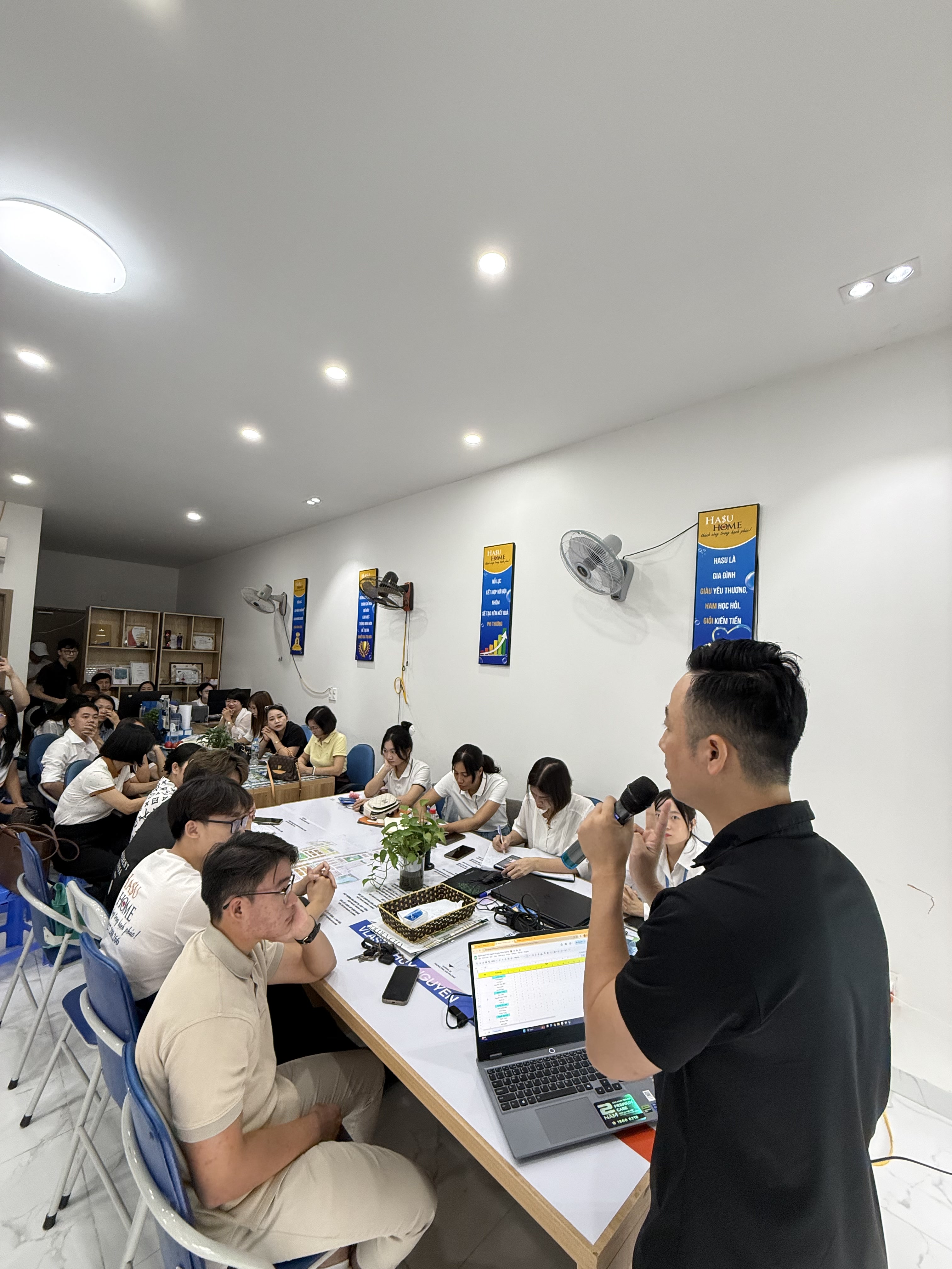 Đăng Dương trao đổi với học viên ngồi kín hai dãy bàn dài trong buổi đào tạo tại sàn
