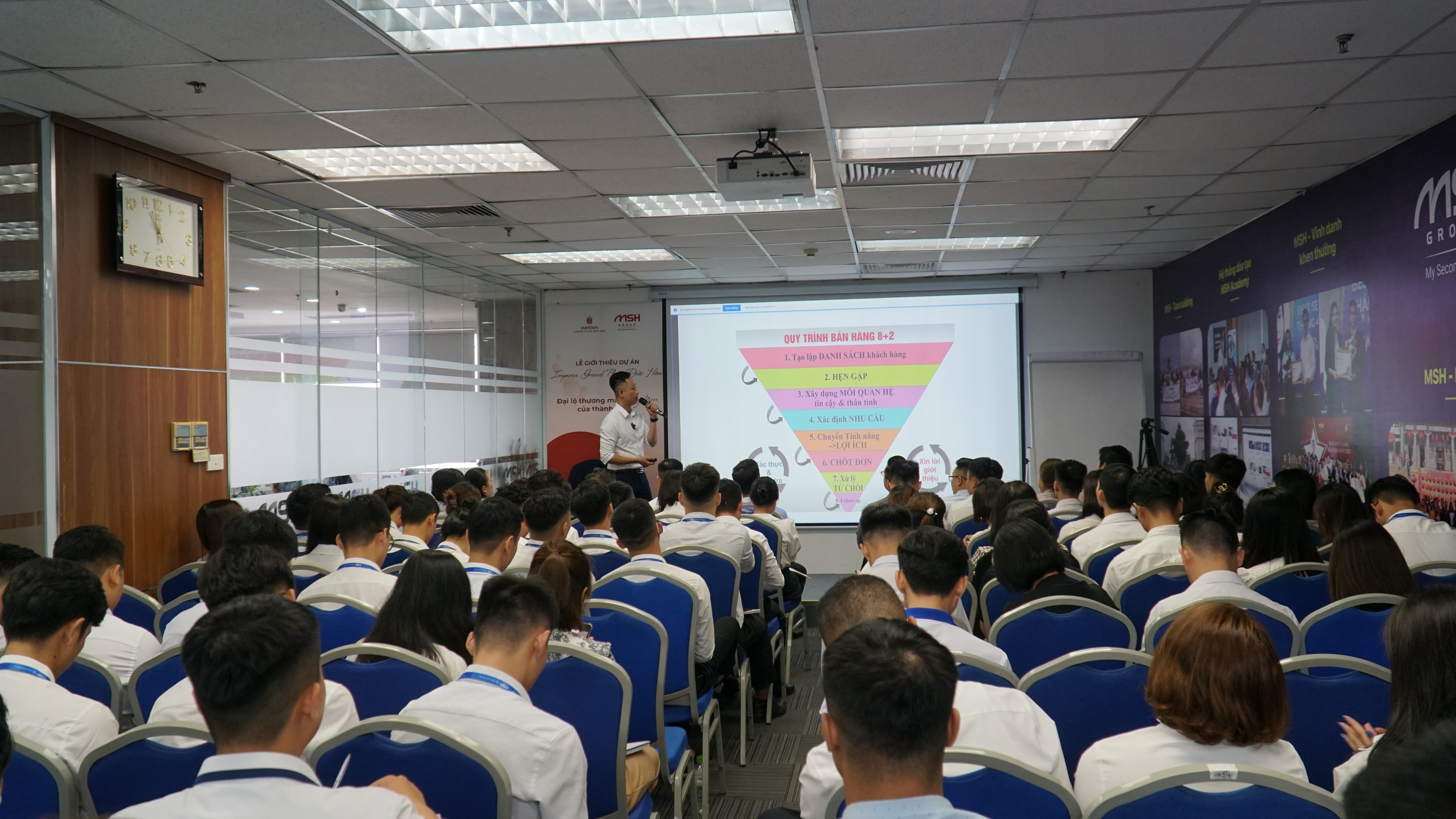 Đăng Dương cầm micro nói trước lớp về nguyên tắc hoàn thành hơn hoàn hảo khi làm video bất động sản