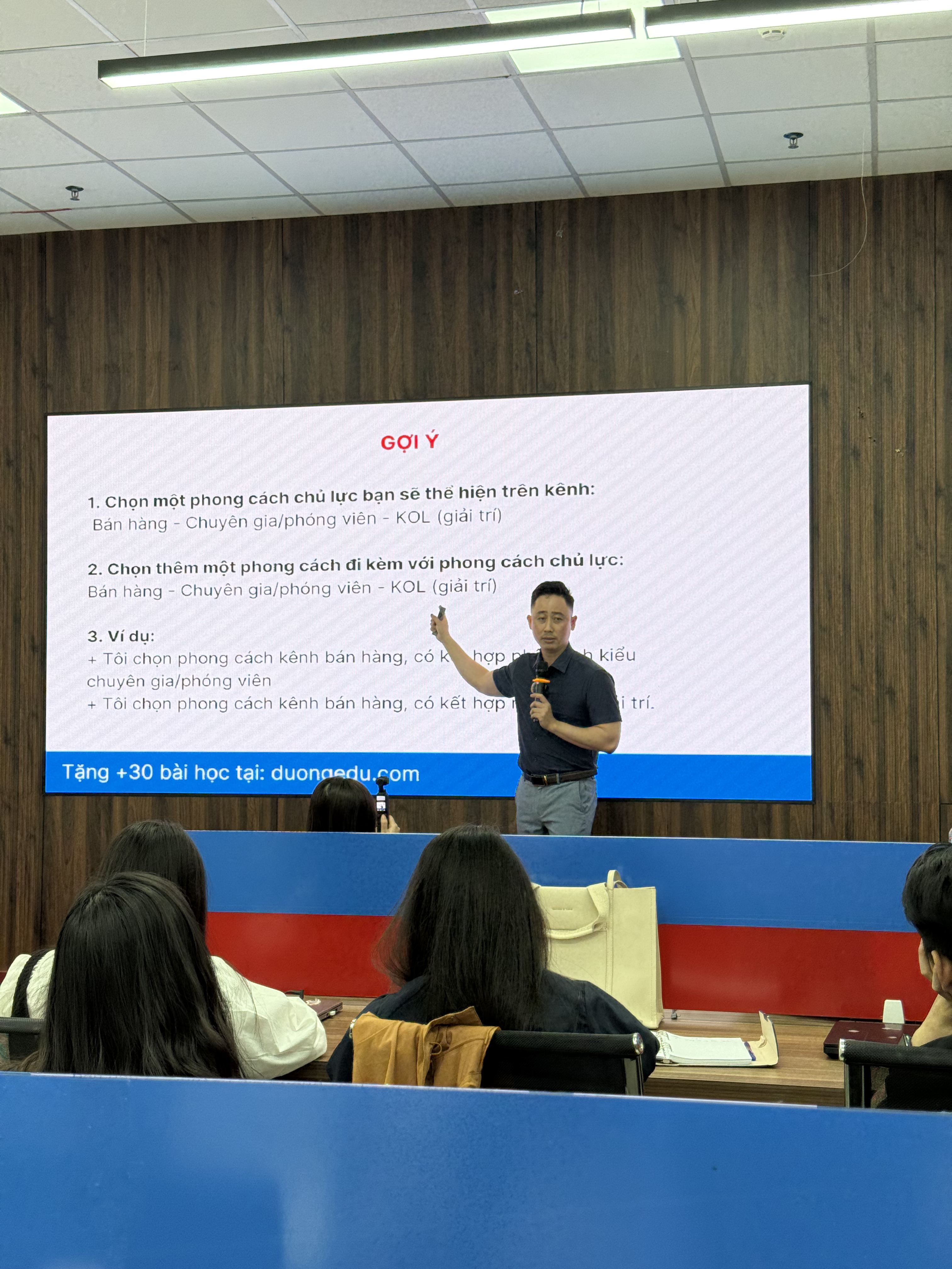 Đăng Dương giơ tay chỉ vào slide gợi ý phong cách chủ lực khi xây kênh bất động sản