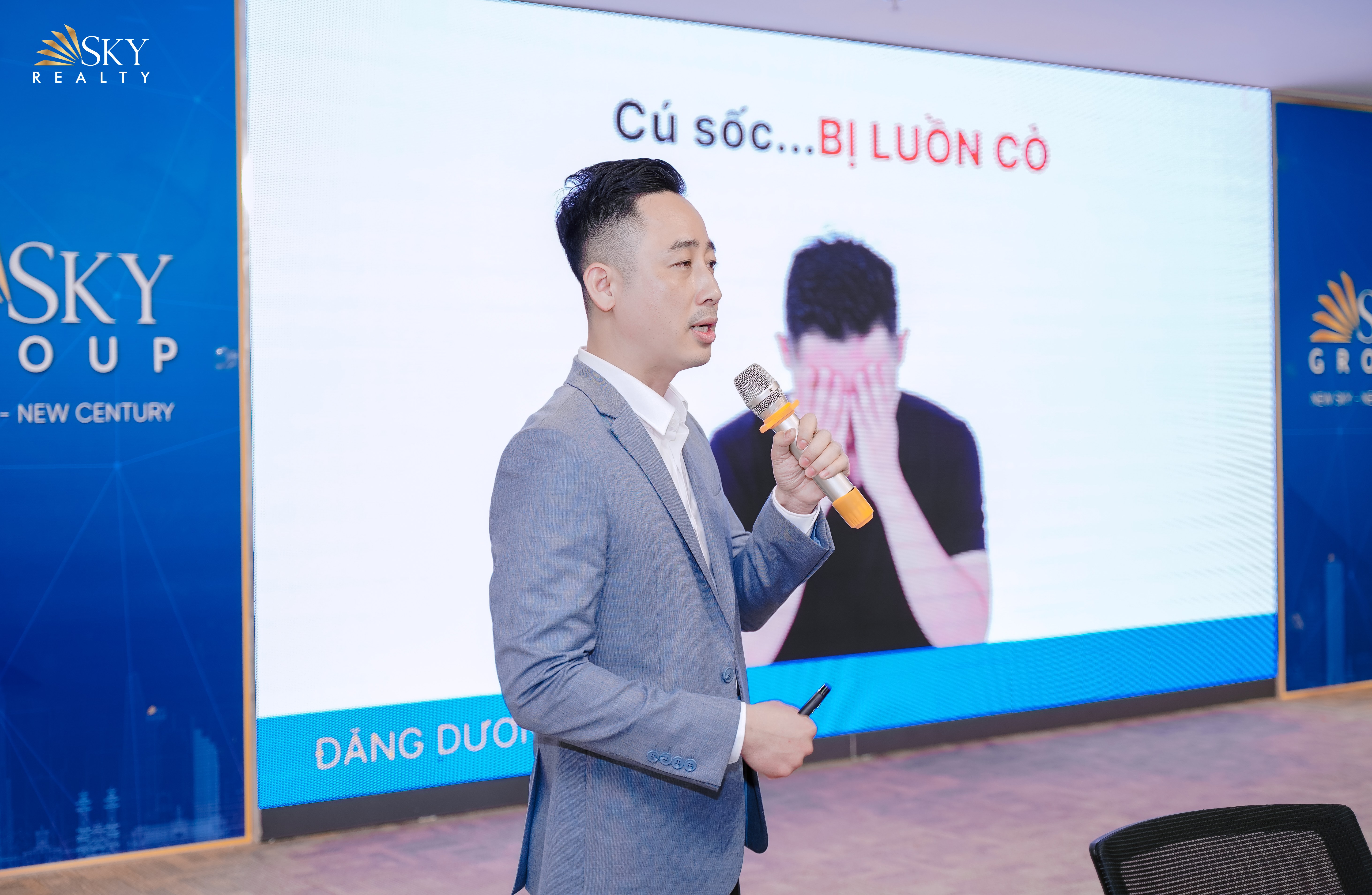 Đăng Dương đứng trước đội ngũ sale bất động sản trong một buổi làm việc tại sàn